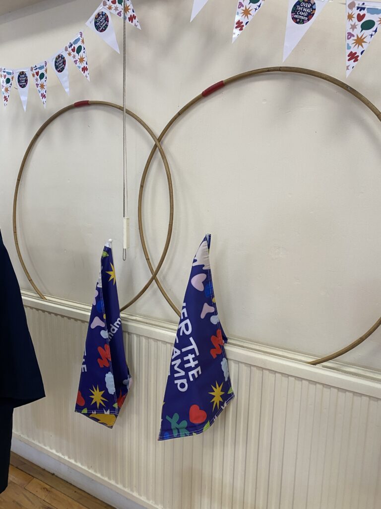 Two wooden hula-hoops and some Over The Wall Camp flags